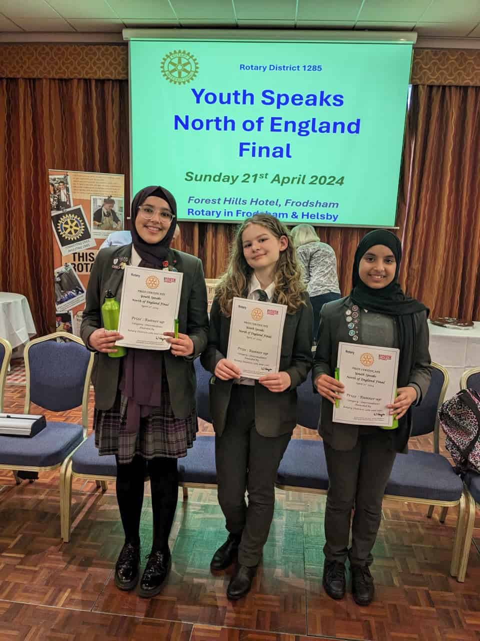  Three students from Laurus Cheadle Hulme smile as they hold their certificates which they received as the Intermediate Runners Up of the Rotary Youth Speaks North of England Final 2024.