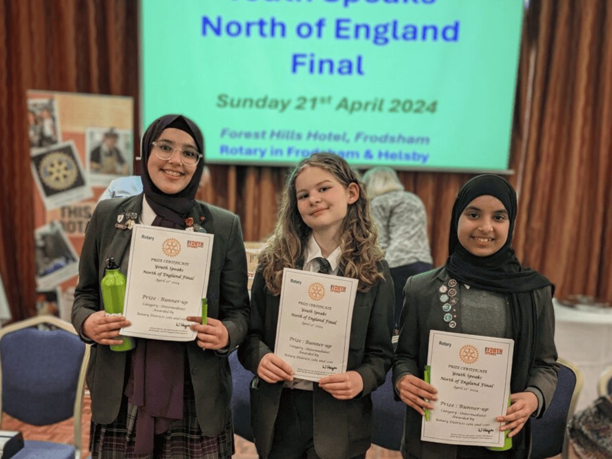 Three students from Laurus Cheadle Hulme smile as they hold their certificates which they received as the Intermediate Runners Up of the Rotary Youth Speaks North of England Final 2024.